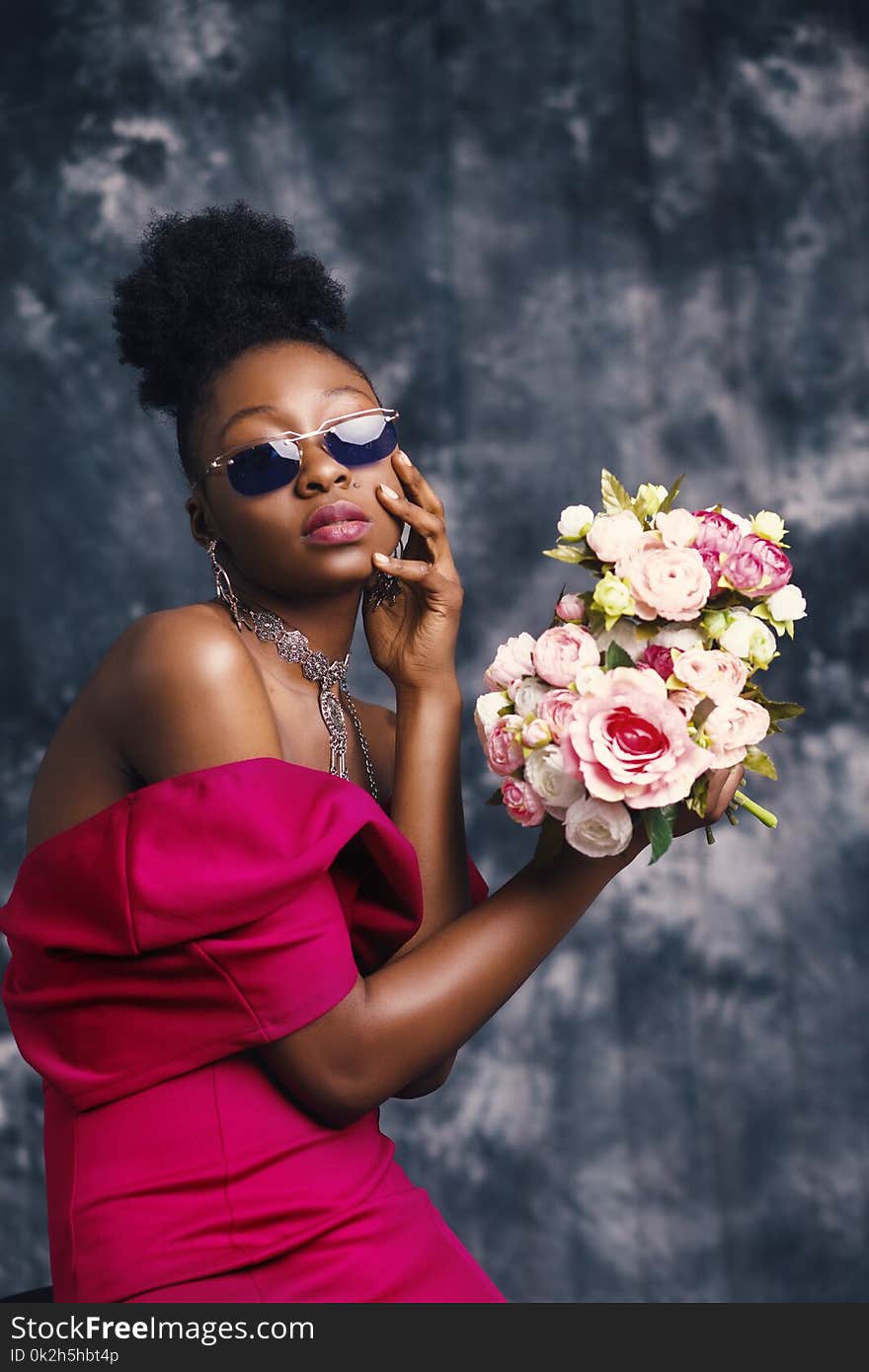 Woman Wearing Sunglasses and Posing for Pic With Flowers