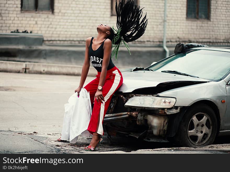 Woman in Black Tank Top Sitting in Front of Car