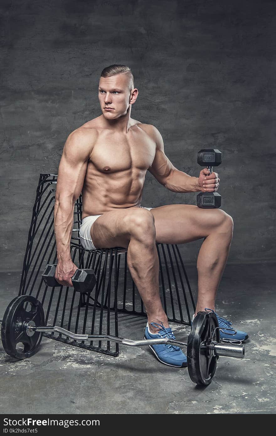 Shirtless muscular man posing in studio.