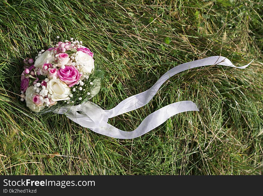 Romantic fresh colorful wedding bouquet of roses on green grass with white textile lace and smal cute flowers in summer day. Romantic fresh colorful wedding bouquet of roses on green grass with white textile lace and smal cute flowers in summer day