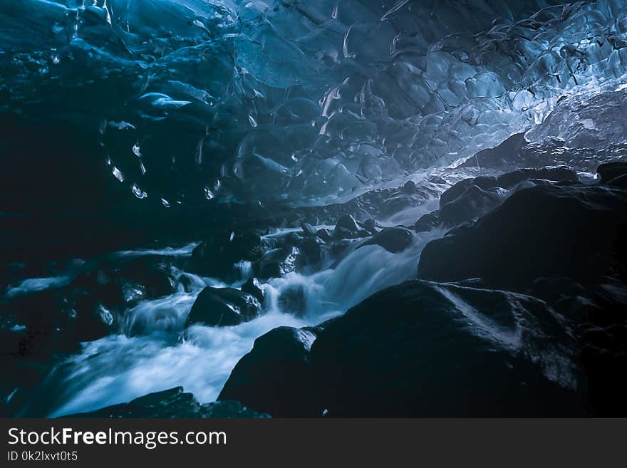 Running stream in an emerald blue ice cave of Vatnajokull ice glacier, Iceland