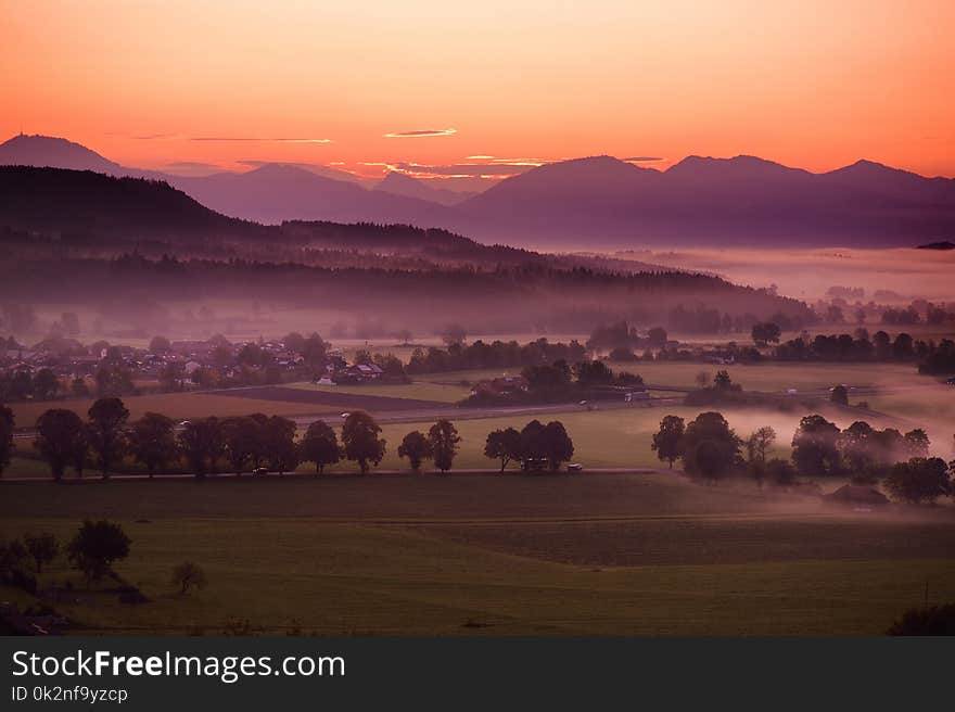 Breathtaking morning lansdcape of small bavarian village covered in fog. Scenic view of Bavarian Alps at sunrise with majestic mou