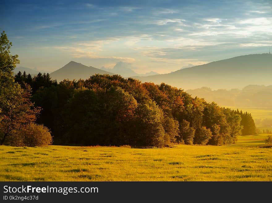 Breathtaking lansdcape of Austrian countrye on sunset. Dramatic sky over idyllic green fields of Anstrian Central Alps on early autumn evening.