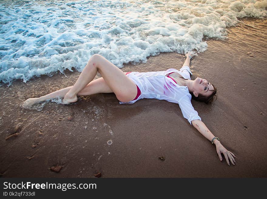 Girl rests and has fun in sea wave at sunset in the evening