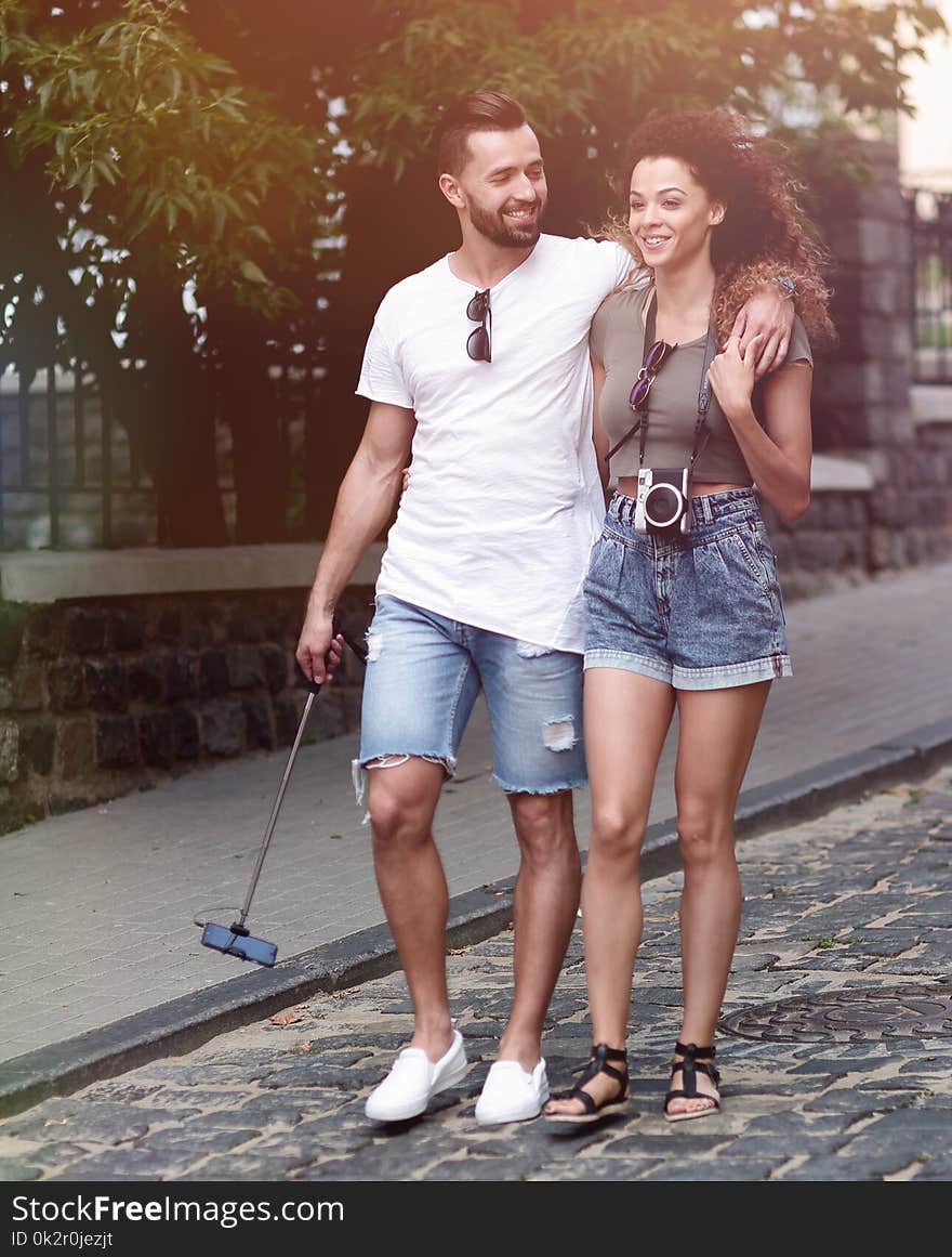 Cheerful young couple walking on urban street