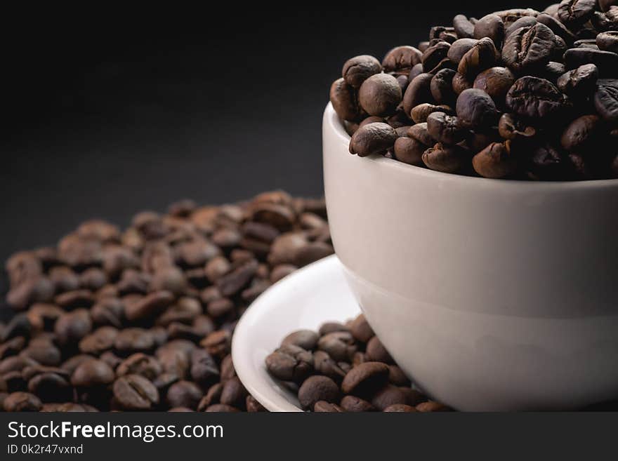 Hot coffee in cup and coffee beans are the background.