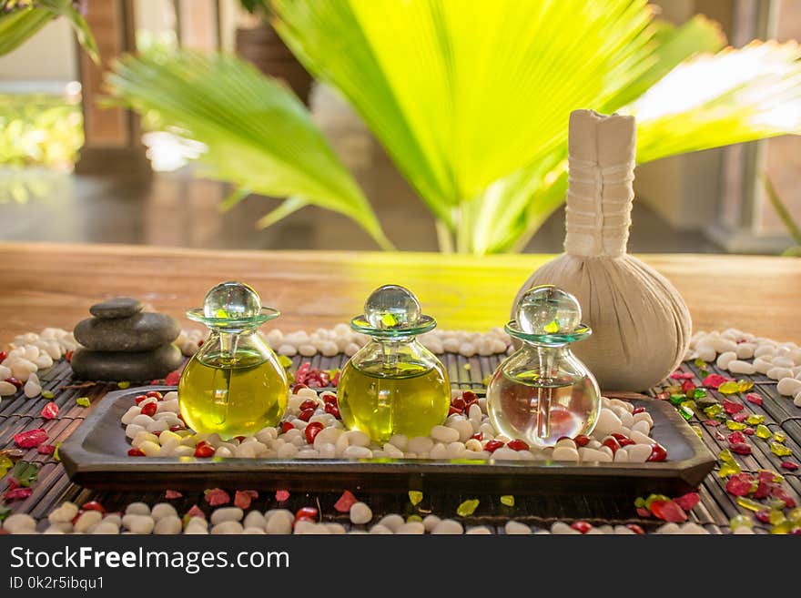 Three glass bottles with aromatic scent and spice on the wooden table at the SPA
