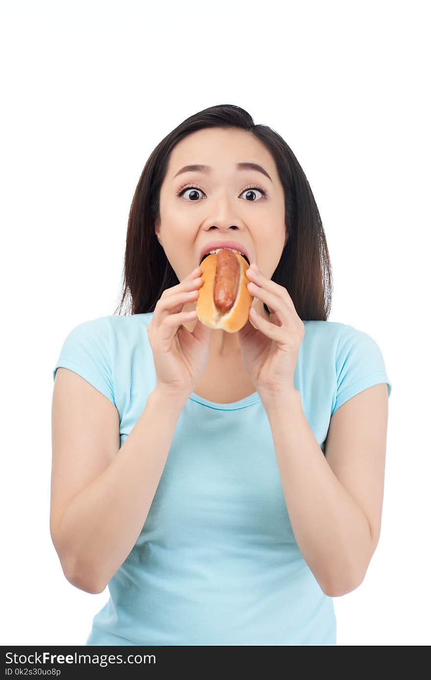 Excited Asian young woman devouring tasty hot dog. Excited Asian young woman devouring tasty hot dog