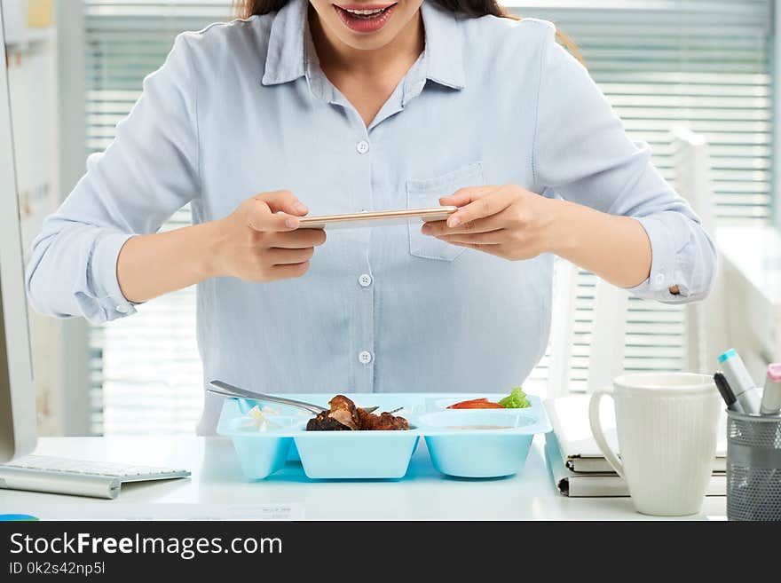 Cropped image of business woman taking photo of lunch before eating it. Cropped image of business woman taking photo of lunch before eating it