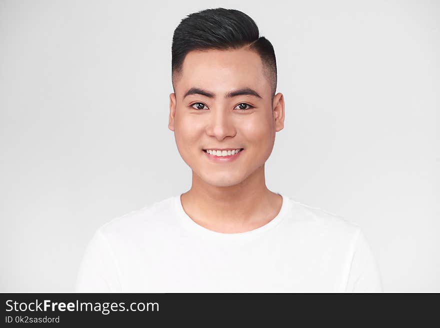 Portrait of handsome young asian man against grey background