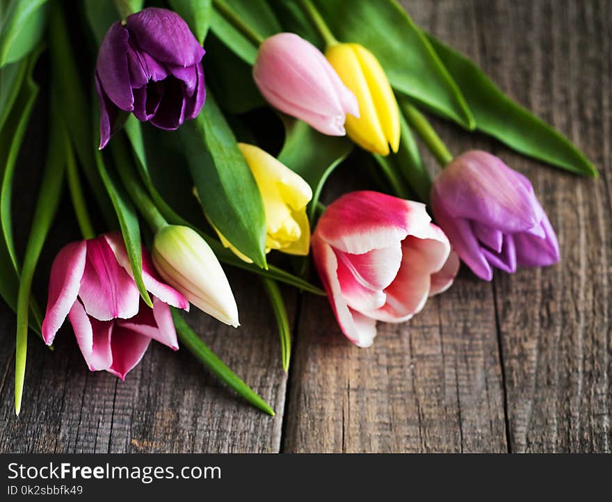 Spring tulips flowers on a white wooden background