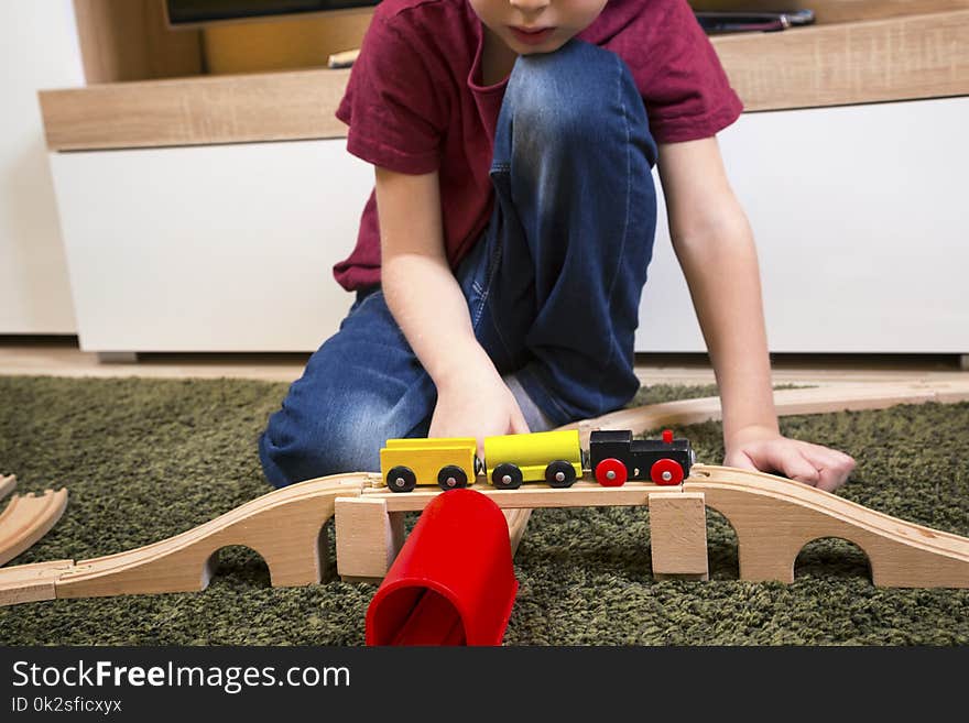 Children play with wooden toy, build toy railroad at home or daycare. Toddler boy play with train and cars. Educational toys for preschool and kindergarten child. Children play with wooden toy, build toy railroad at home or daycare. Toddler boy play with train and cars. Educational toys for preschool and kindergarten child.