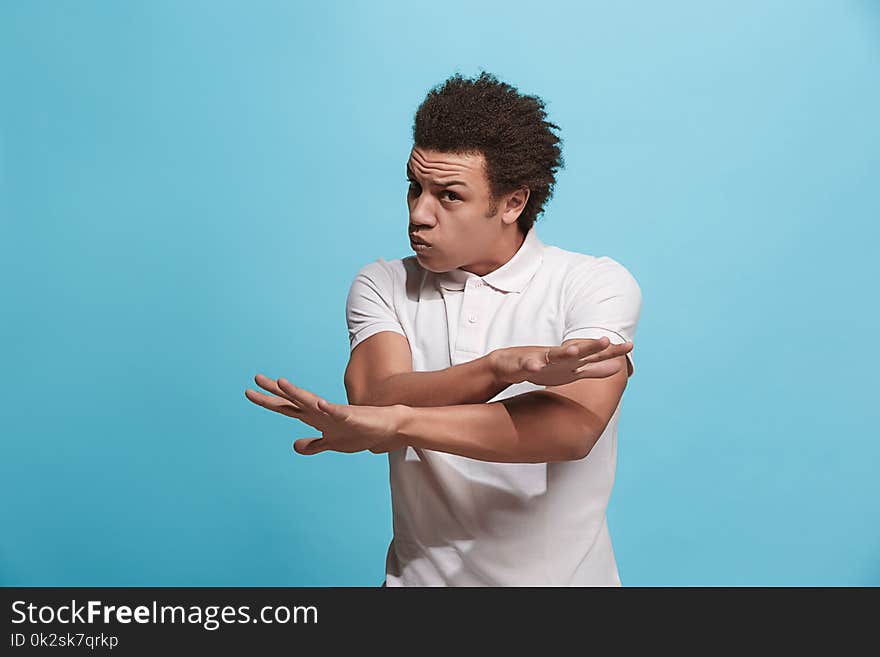 Beautiful male half-length portrait isolated on blue studio backgroud. The young emotional afro man