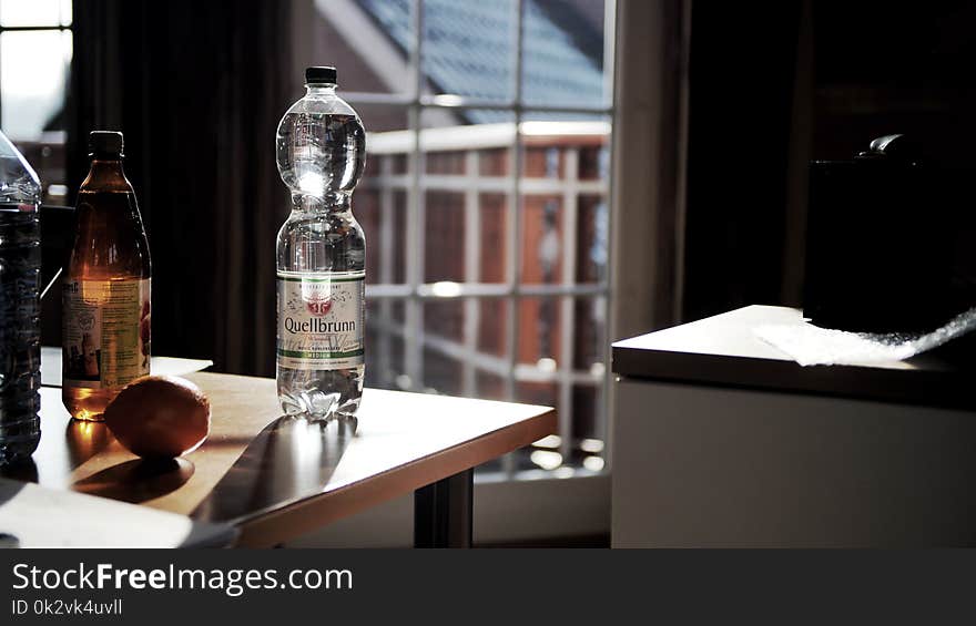 Glass Bottle on Brown Wooden Table