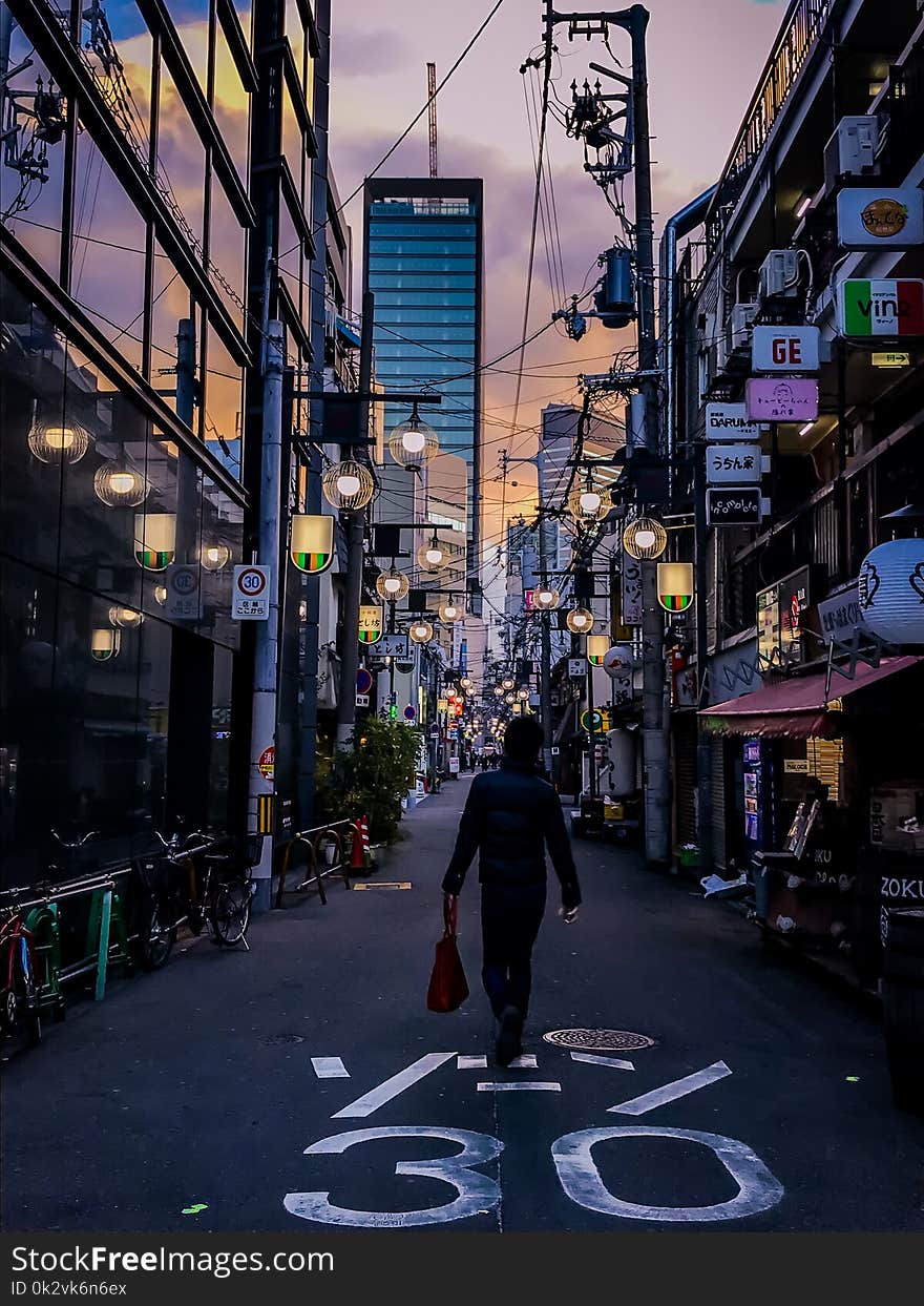 Person in Black Jacket Carrying Red Handbag