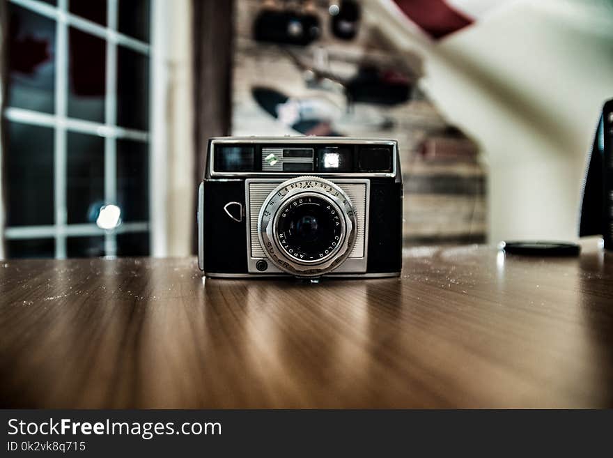 Silver and Black Shallow Focus Camera on Table