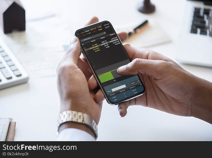 Person Holding Smartphone in Front of Desk