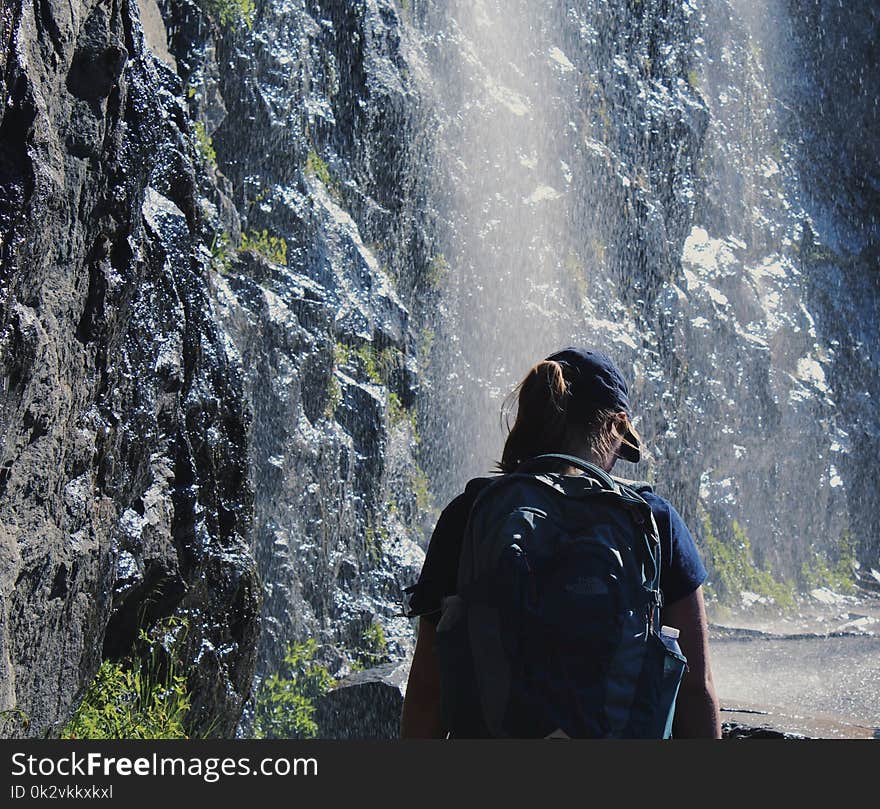 Person Walking Under Waterfalls