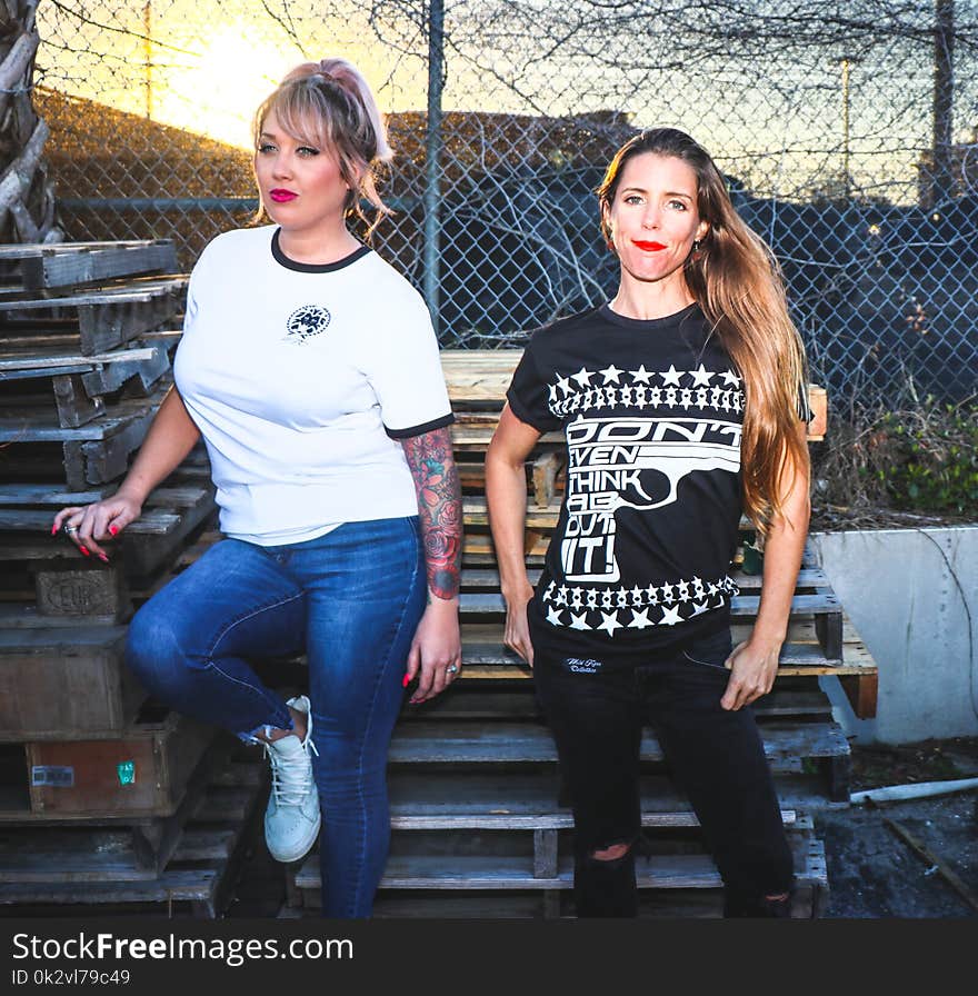 Two Women Taking Picture Near Pallets