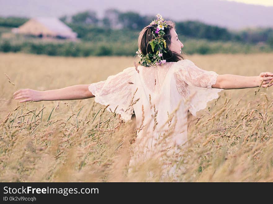 Woman in White Mesh Dress Surrounded by Brown Plants