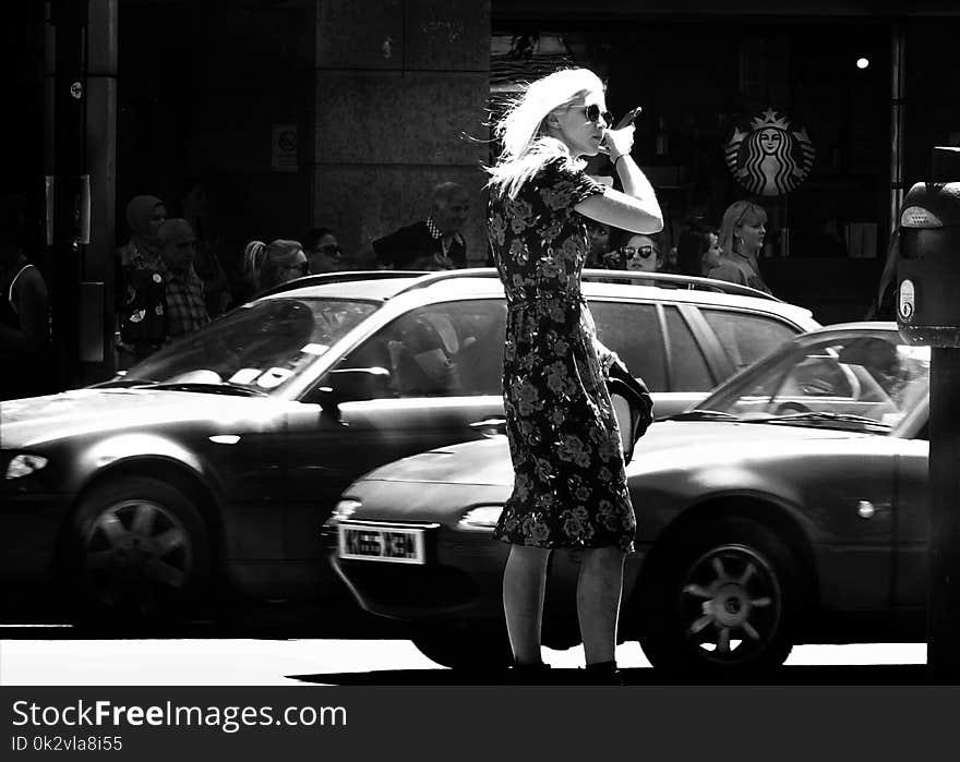 Woman Wearing Floral Short-sleeve Dress Standing Beside Car Grayscale Photo