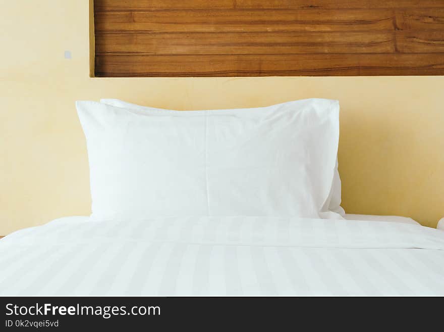 Comfortable white pillow on bed decoration in hotel bedroom interior