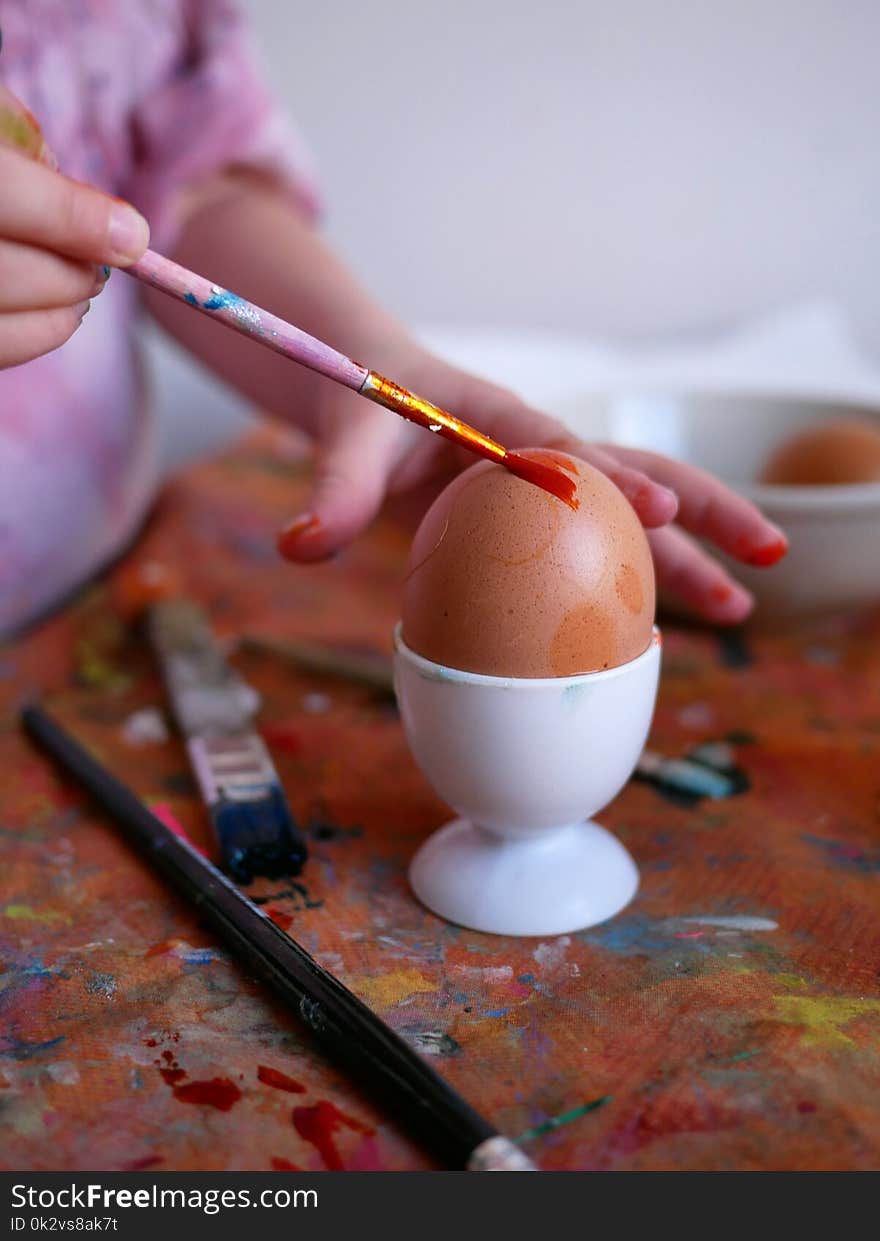 The Traditional Eastern - The egg is being painted by a brush in hands of a little czech girl.