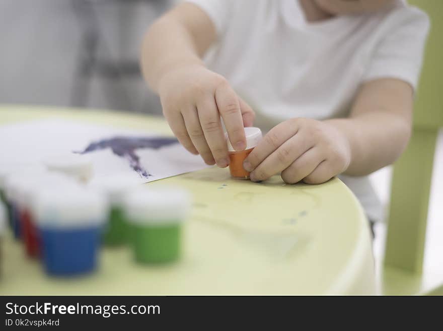 Portrait of adorable little asian boy holding a paintbrush and working on a painting for art class in school.Confidence