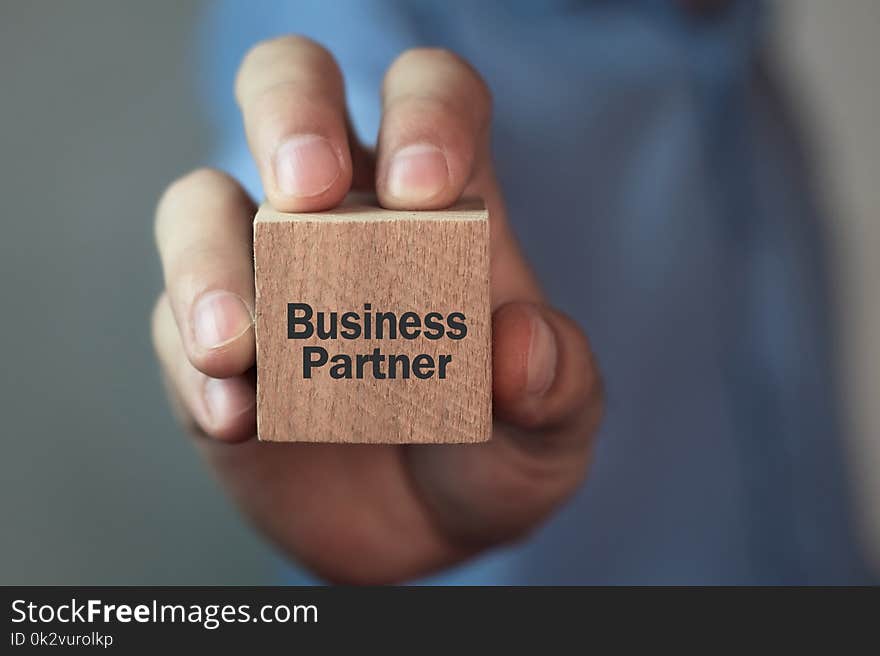 Man showing Business Partner text on wooden cube. Business