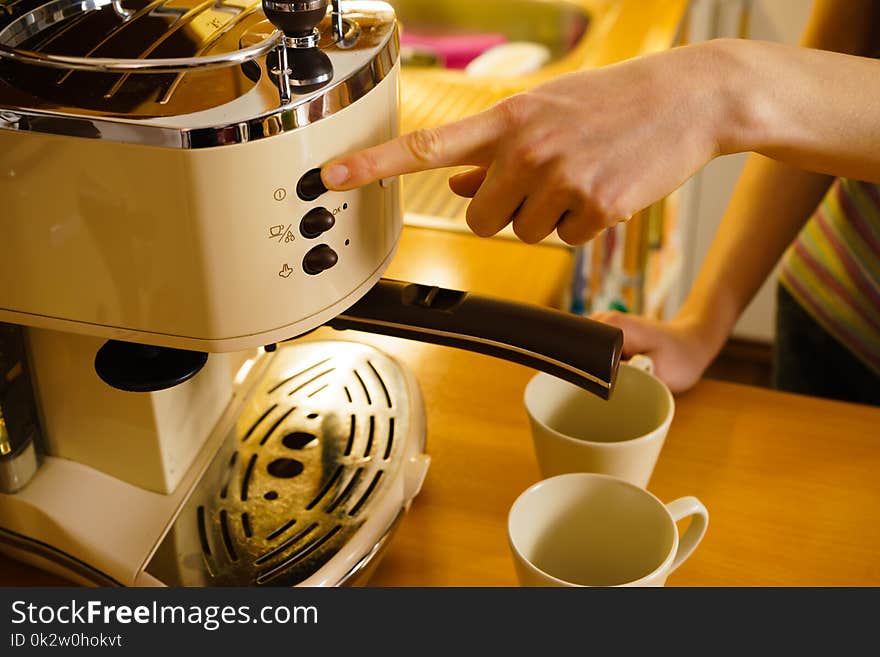 Woman making hot drink in coffee machine