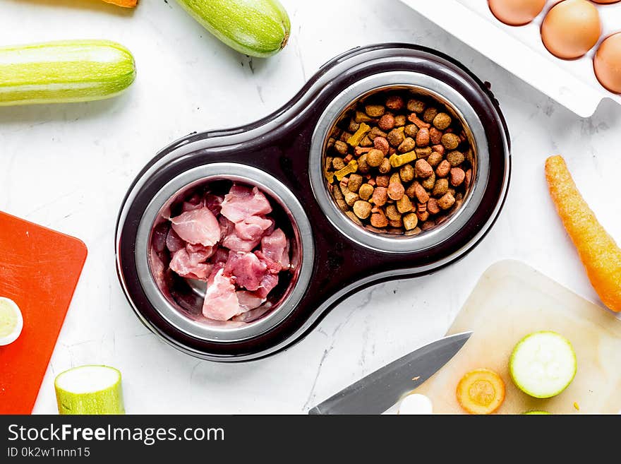 Dogfood set with cut fresh vegetables and knife on white kitchen table background top view. Dogfood set with cut fresh vegetables and knife on white kitchen table background top view