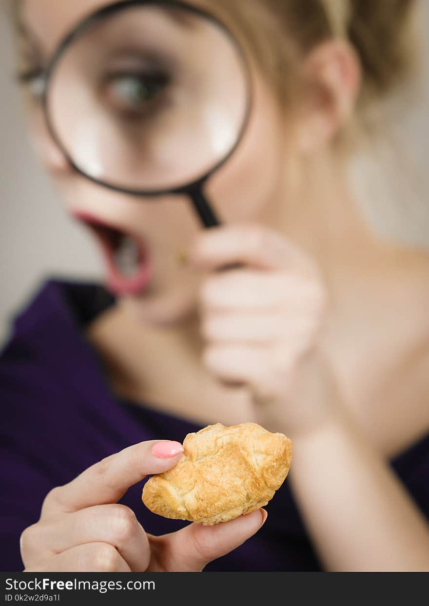 Woman holding magnifying glass investigating bread