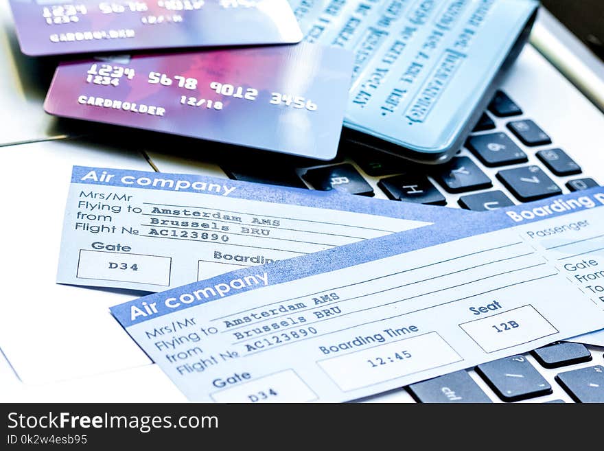 Credit cards with airline tickets for vacations on laptop backgr