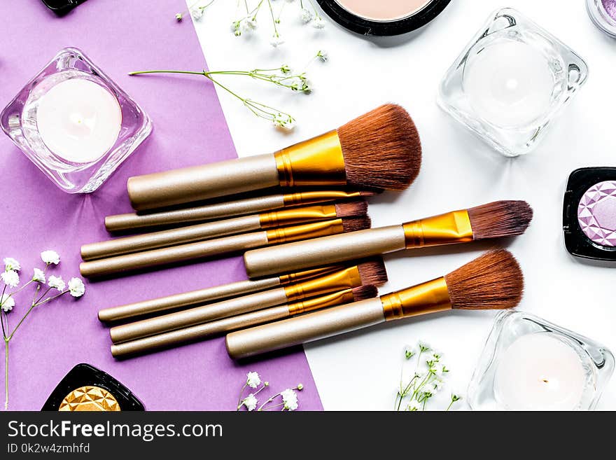 Decorative cosmetics pattern with eye shadow and make-up brushes on colorful background top view. Decorative cosmetics pattern with eye shadow and make-up brushes on colorful background top view