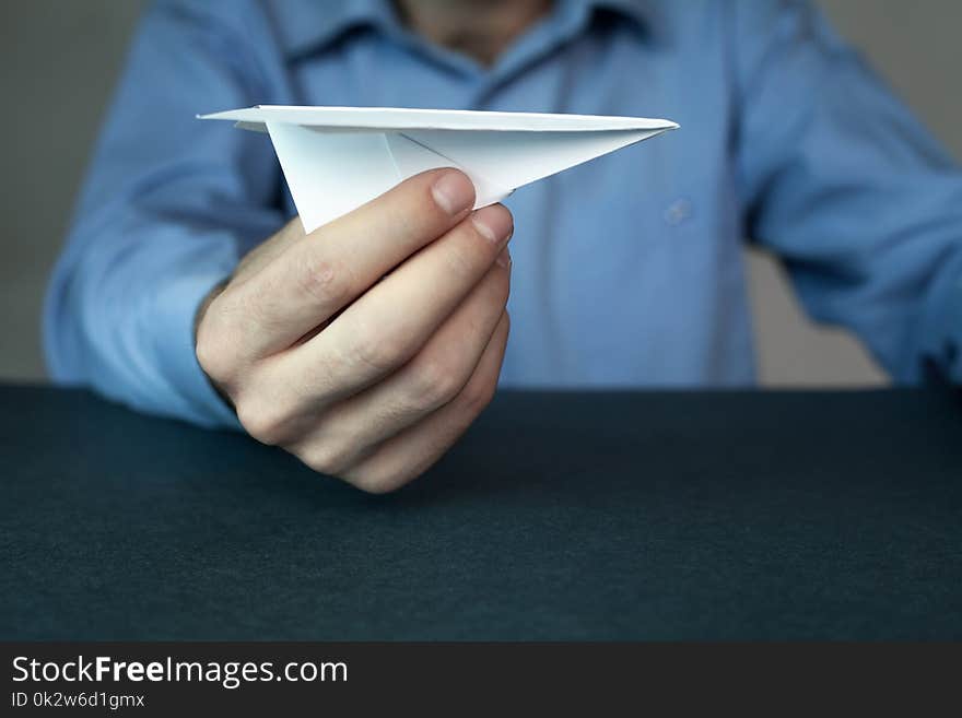 Businessman holding paper airplane.