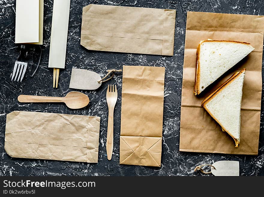 Food delivery with paper bags and sandwich on gray background to