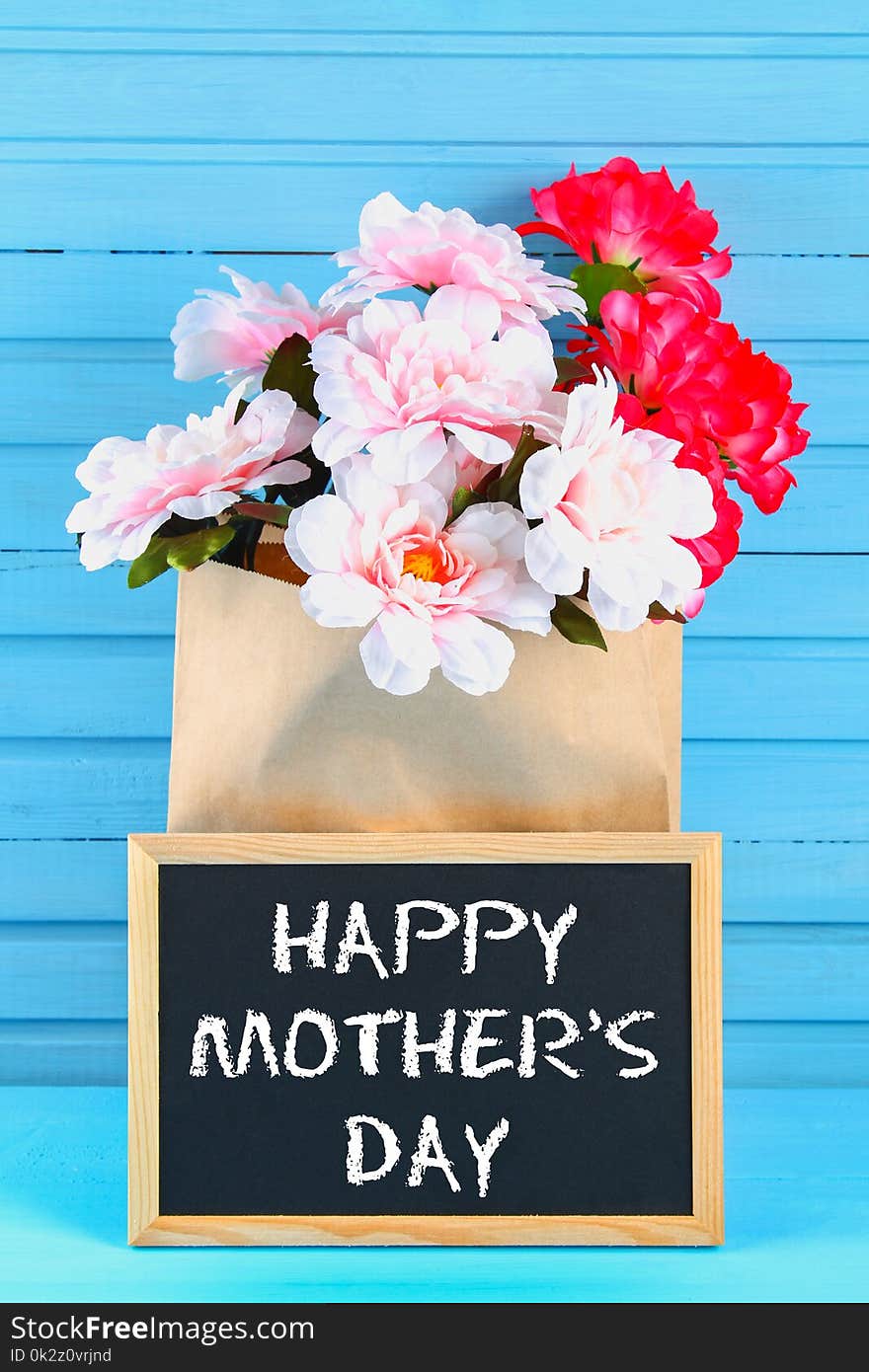 Pink Peonies In A Craft Package With A Chalkboard On A Blue Wooden Table. Postcard For The Holiday. Happy Mother`s Day