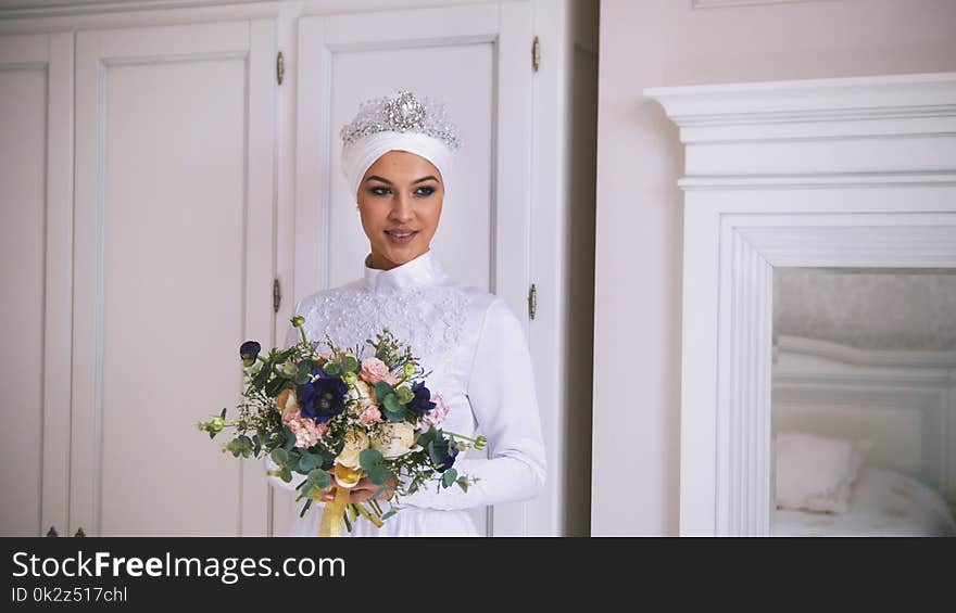 Beautiful muslim bride with make up in wedding dress with white headdress