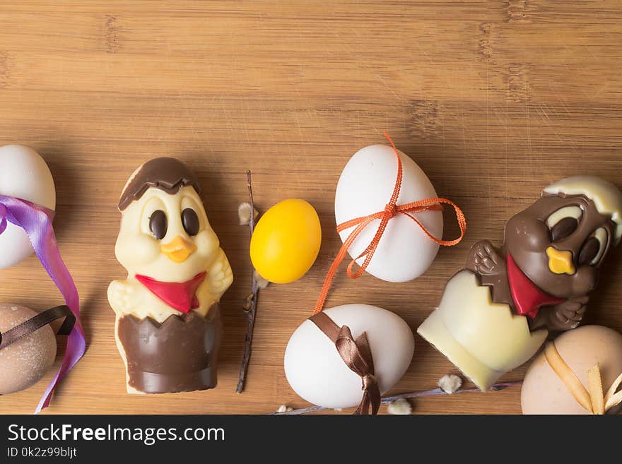 easter eggs with color ribbon and chocolate cute chicken on the orange background