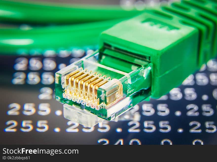 Green ethernet cable detail. Routing table on the background.