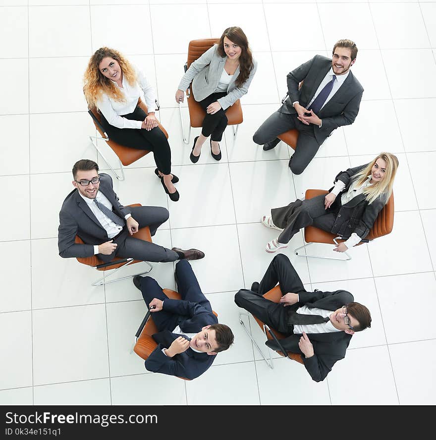 View from the top.successful business team sitting in a circle and looking at the camera.