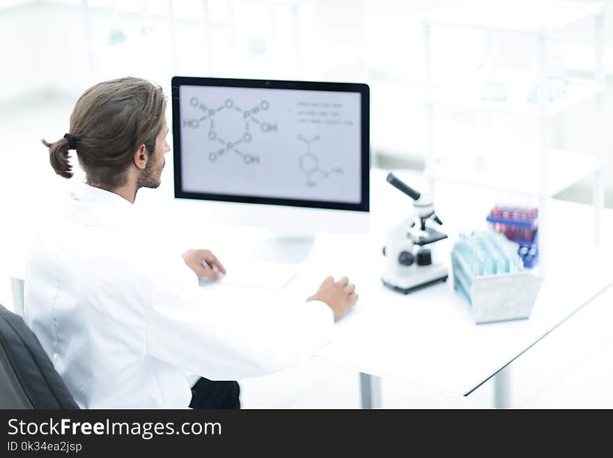 Young man working in a medical lab using a computer