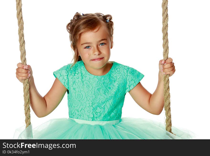 Beautiful little girl swinging on swing. The concept of family happiness, child development, sports education and summer recreation. Isolated on white background. Beautiful little girl swinging on swing. The concept of family happiness, child development, sports education and summer recreation. Isolated on white background.