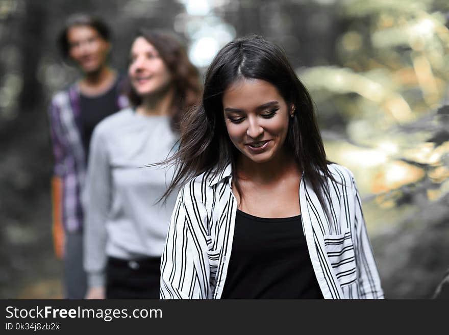 Closeup.girl leader leads his team along a forest road