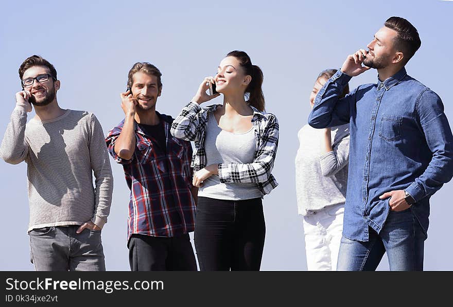 Group Of Students Talking On Their Smartphones.