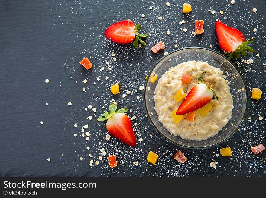 Oatmeal for Breakfast with strawberries and dried fruits still Life on black background. Oatmeal for Breakfast with strawberries and dried fruits still Life on black background