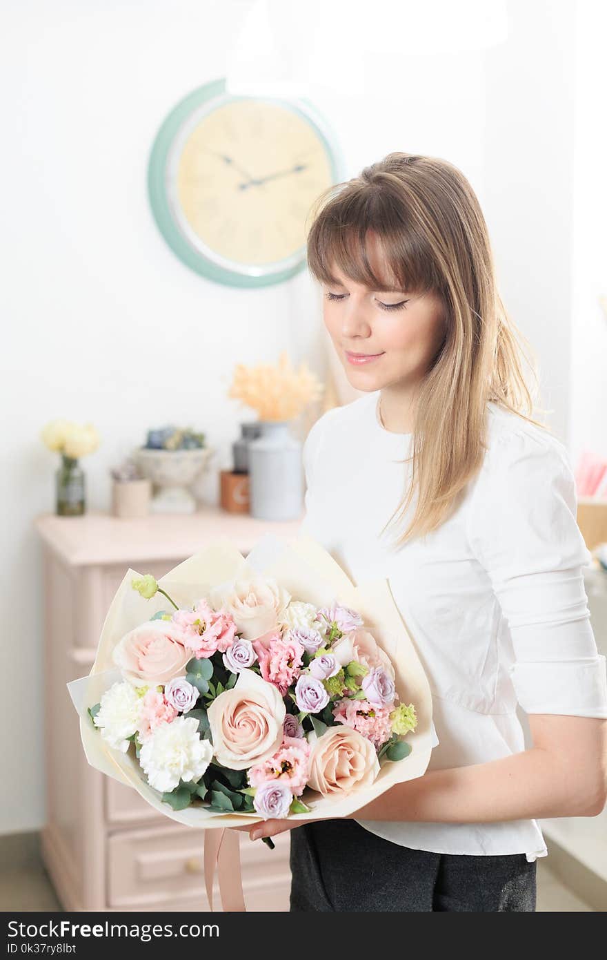 Beautiful luxury bouquet of mixed flowers in woman hand. the work of the florist at a flower shop. A small family business.