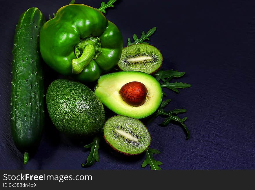 Green assortment vegetables and fruits, avocados, kiwi, pepper and cucumber on a shale board, the concept of healthy eating, copy