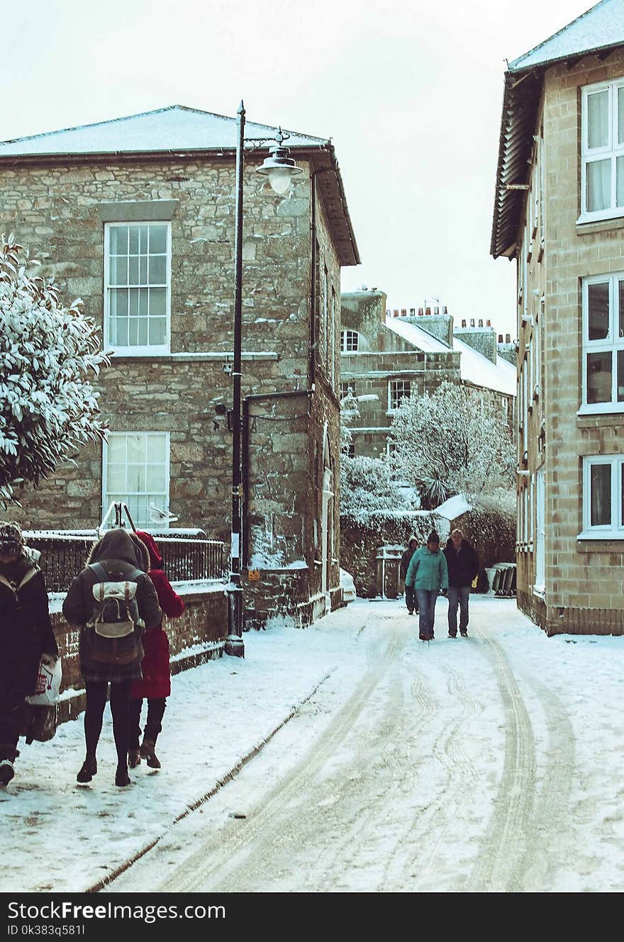 People Walking on Snow Covered Street