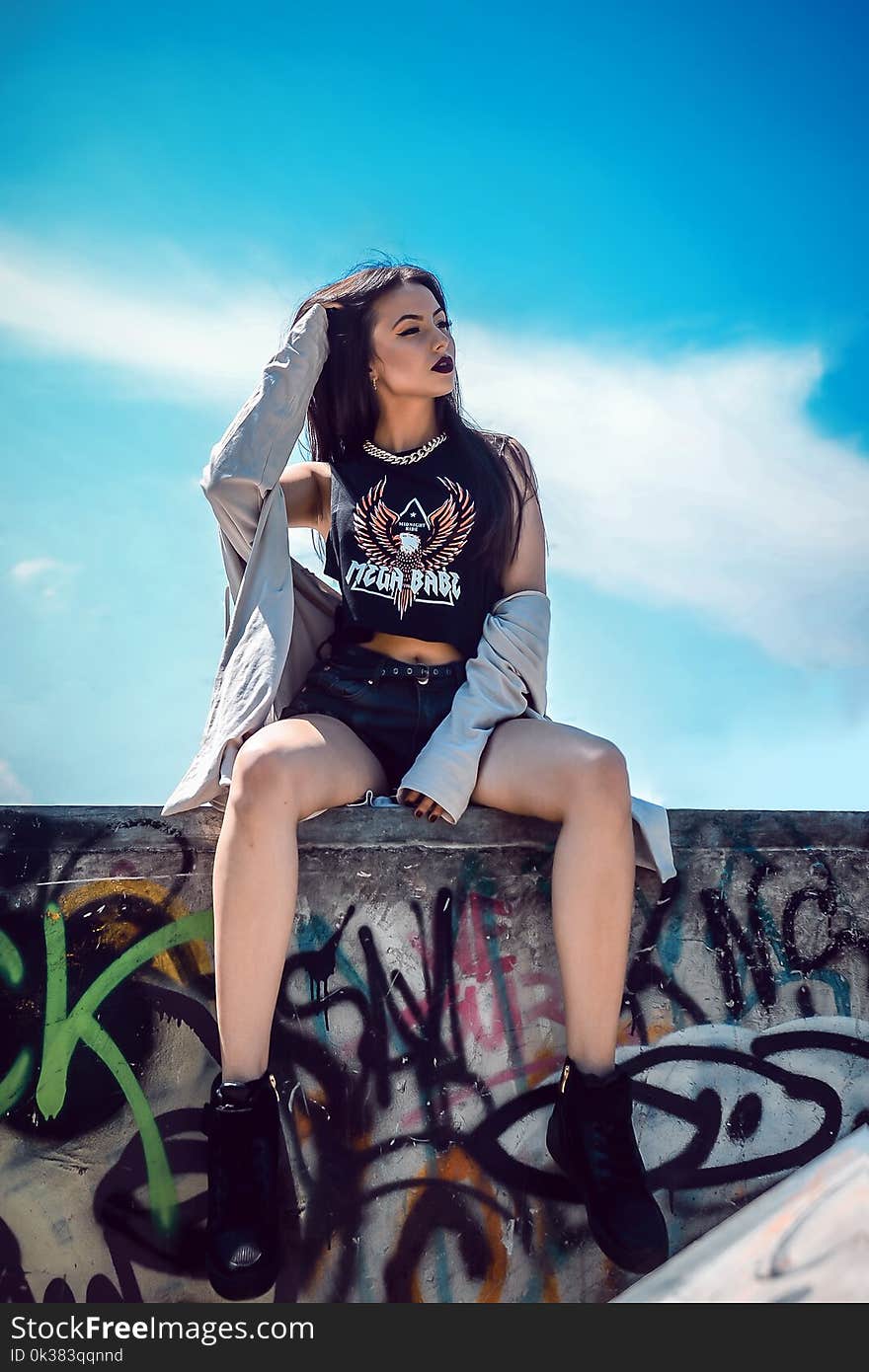 Photo of a Woman Sitting on a Ledge